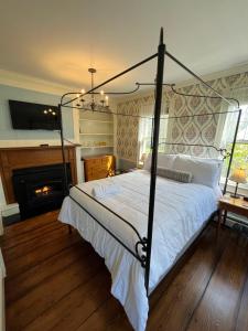 a bedroom with a canopy bed and a fireplace at Chester Inn in Chester