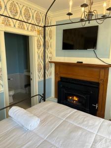 a bedroom with a bed with a fireplace and a television at Chester Inn in Chester +44 photos