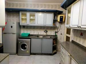 a kitchen with a sink and a washing machine at Exquisite Vacation Home at Zomoroda Village - North Coast in Dawwār Shindī Fannūsh