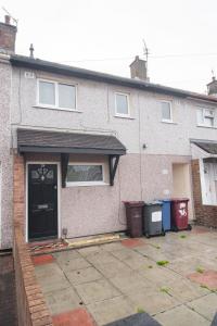 una casa con una puerta negra y dos botes de basura en Quiet 3 bed house, pet friendly, en Kirkby