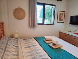 a bedroom with a bed with towels on it at Lefkada Eli's amazing beach house in Nikiana