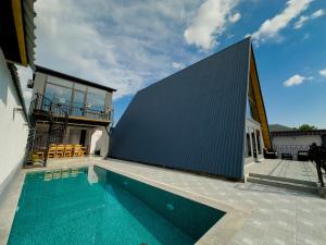 a house with a swimming pool next to a building at Qafqaz Twin A Frame in Gabala