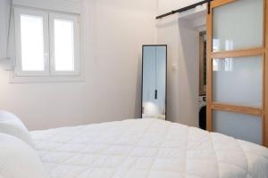 a white bedroom with a bed and a mirror at Casa d'oro 56 Living in Paradisi Rhodes in Paradeísion