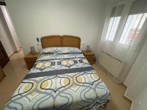 a bedroom with a bed with a bedspread on it at Atico in Tomelloso