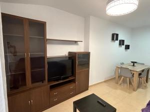 a living room with a large entertainment center and a table at Atico in Tomelloso