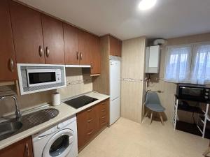a small kitchen with a sink and a microwave at Atico in Tomelloso