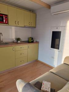 a kitchen with yellow cabinets and a couch in a room at Fancy Maisonnette in Gura Humorului +8 photos