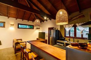 a kitchen with a counter and a kitchen with a refrigerator at Vila Inca in Alto Paraíso de Goiás
