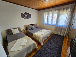 a bedroom with two beds and a window at Sara Family Home in Struga