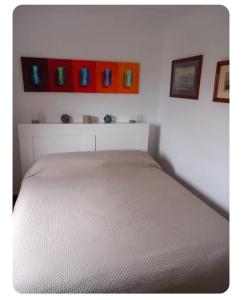 a bed in a bedroom with some pictures on the wall at Casa Pierina in Anacapri