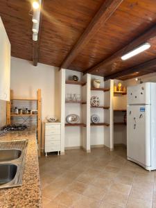 a kitchen with a white refrigerator and a sink at Monsant Casa Vacanze in Granelli