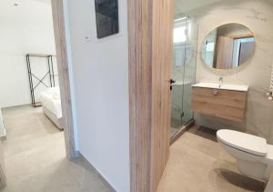a bathroom with a toilet and a sink and a mirror at K78 Studios A1 in Nea Michaniona
