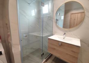 a bathroom with a sink and a shower with a mirror at K78 Studios A1 in Nea Michaniona +2 photos
