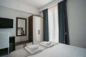 a bedroom with a bed with two towels on it at Hotel Baia Marina in Cupra Marittima
