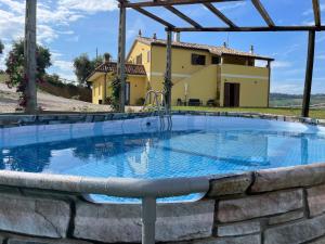 una grande piscina con una casa sullo sfondo di Lí da Ste a Ripatransone