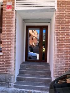 a stairway with a glass door in a brick building at AR Apartamentos Manzanares El Real in Manzanares el Real
