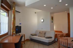 a living room with a white chair and a table at Apartments Ballabanka in Koper
