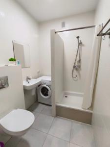 a white bathroom with a toilet and a shower at ЖК Времена года Весна Кабанбай Батыра 46 in Taldykolʼ