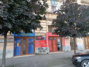 a building with red and blue doors on a street at Casa Heidi in Timişoara