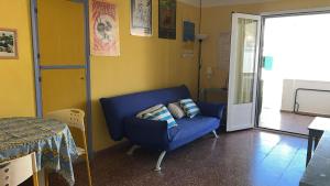 a living room with a blue couch and a table at Es Grau Lamorino in Es Grau