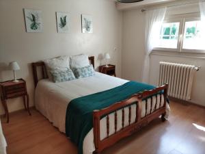 a bedroom with a large bed and two windows at Maison de campagne in Thorigné-dʼAnjou