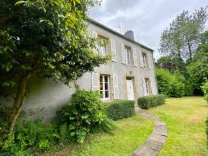 LanvellecにあるMaison entre campagne et merの芝生の庭のある大きな白い家