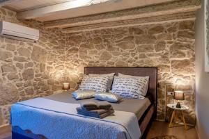 a bedroom with a bed in a stone wall at Villa Veselici in Labin +48 photos