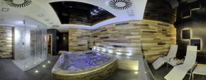 einen Wellnessraum mit einer Badewanne in einer Steinwand in der Unterkunft Hotel Purkmistr in Pilsen