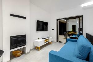 a living room with a blue couch and a tv at Villa Mare in Vinišće