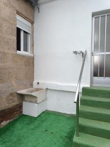 a building with a green floor and stairs and a window at Casa Miguel in Teis