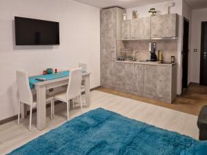 サニービーチにあるАпарткомплекс Амара Слънчев Бряг Студио 13のテーブルと椅子のあるキッチンとダイニングルーム +5枚の写真