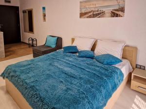 サニービーチにあるАпарткомплекс Амара Слънчев Бряг Студио 13の青い毛布が掛けられた大きなベッドのある寝室