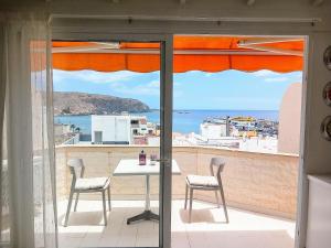 ロス・クリスティアーノスにあるCasa Sonnyの海が見えるバルコニーにテーブルと椅子がある
