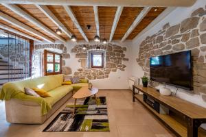 a living room with a yellow couch and a tv at Villa Veselici in Labin
