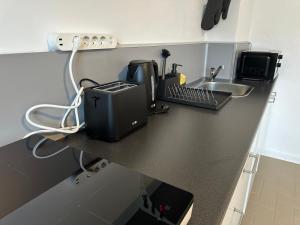 a kitchen counter with a sink and a appliance on it at BSD Apartment - Self Check-in & Parkplatz in Bochum +2 photos