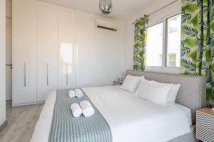 a bedroom with a large white bed with slippers on it at Happy Tucan in Larnaka