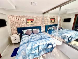 a bedroom with two beds and a brick wall at RECANTO DOS PASSARINHOS LINDA CASA COM 2 quartos in Balneário Camboriú