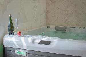 a bath tub with a bottle of wine and a bottle of champagne at Private Spa Balatonfüred in Balatonfüred +8 photos
