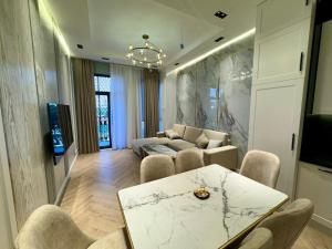 una sala de estar con una mesa y un sofá en Skyline Towers Apartments, en Tashkent