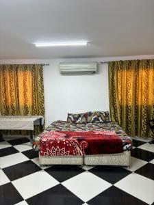 a bedroom with a bed and a checkered floor at LARGE M BEDROOM Attached Bathroom with Terrace Access in a villa Sharjah in Sharjah