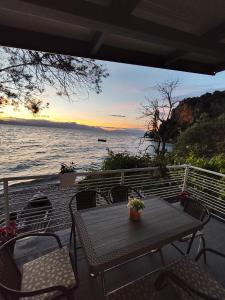 a table and chairs on a deck with a view of the ocean at Apartment DULE Trpejca in Ohrid