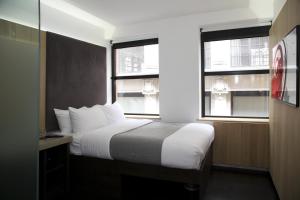 Una habitación de hotel con una cama y dos ventanas. en The Z Hotel City, en Londres 35 fotos más