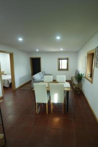 a living room with a table and white chairs at Quintinha de Sá in Arnoso +12 photos