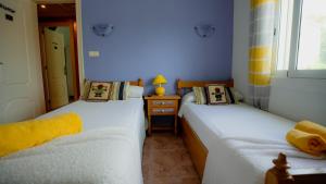 two beds in a small room with blue walls at La Casa de Mima in Cubelles +7 photos