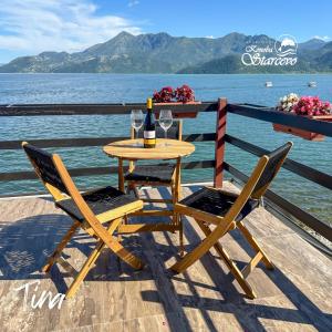 a table with two chairs and a bottle of wine at Apartmani Konoba Starčevo in Virpazar