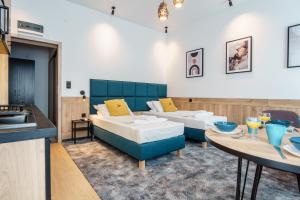 two beds in a room with a table and a kitchen at Noclegi Orla 6 in Lublin