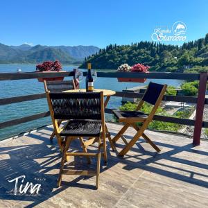 a table and chairs on a deck with a bottle of wine at Apartmani Konoba Starčevo in Virpazar