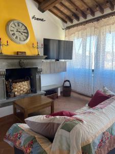 a bedroom with a fireplace and a clock on the wall at Tuscany Location in Marta