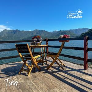 a table and chairs sitting on a deck next to the water at Apartmani Konoba Starčevo in Virpazar