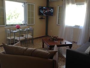 a living room with a couch and a table and a tv at Villa Lucia in Lixouri